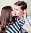 © iordani - couple of happy smiling teenagers students, warm colors having a kiss, lifestyle people concept, boy and girl together close up
