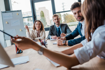 Wall Mural - selective focus of multicultural businesspeople looking at coworker in office