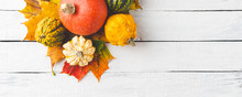 Composition Of Autumn Leaves And Pumpkins On White Wooden Table. Thanksgiving Concept. Banner