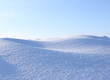 A large beautiful snowdrift and blue sky. Winter  landscape. A big snow drift