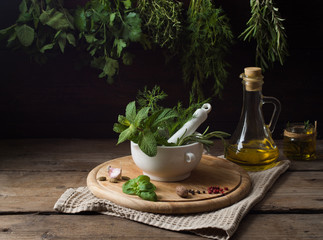 Wall Mural - Fresh spices thyme, turmeric, cardamom, basil, mint, parsley, dill  and rosemary on wooden background.