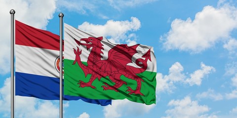 Paraguay and Wales flag waving in the wind against white cloudy blue sky together. Diplomacy concept, international relations.