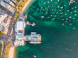 Vertical bird's eye aerial evening drone view of Manly wharf, part of the oceanside suburb of Manly, Sydney, New South Wales, Australia. Two ferries docked at the wharf.