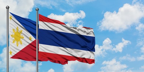 Philippines and Thailand flag waving in the wind against white cloudy blue sky together. Diplomacy concept, international relations.