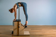 © Georgii - Palates trainer girl posing for a reformer in the gym. Fitness concept, special fitness equipment, healthy lifestyle, plastic. Copy space, sport banner for advertising.