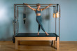 © Georgii - Pilates woman in a Cadillac reformer doing stretching exercises in the gym. Fitness concept, special fitness equipment, healthy lifestyle, plastic. Copy space, sport banner for advertising