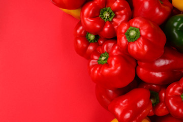 Fresh red, yelow, green bell pepper on a red background.