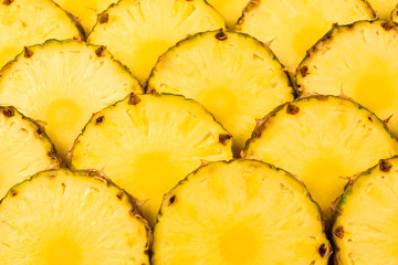 Pineapple juicy yellow slices background. Top view.