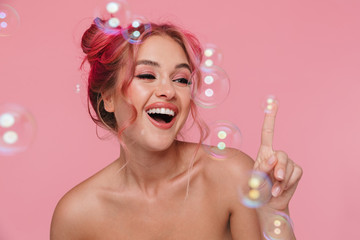 Canvas Print - Portrait of young shirtless woman smiling and posing with soap bubbles