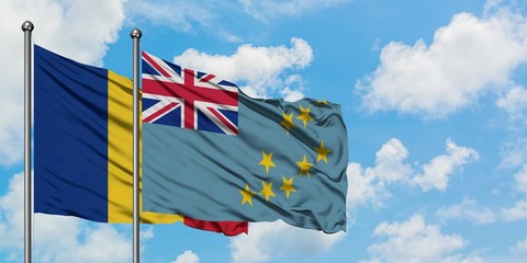 Romania and Tuvalu flag waving in the wind against white cloudy blue sky together. Diplomacy concept, international relations.