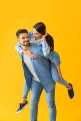 Wall Mural - Portrait of happy young couple on color background