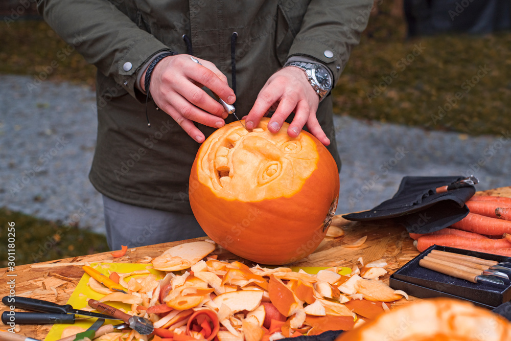 The process of cutting the Halloween pumpkins,. Men's hands with a