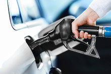 Woman Pumping Petrol At Gas Station Into Vehicle. Hand Holding A Pistol Or Nozzle Pump Prepare To Refuel Car With Gasoline.