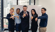 © ronnachaipark - Successful cheerful business people group of multiracial business team with thumbs up and smiling posing