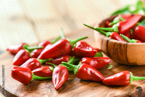 Cuadros en Lienzo Red hot peppers in old wooden bowl side view