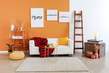 Stylish Interior Of Room With Sofa And Pumpkins