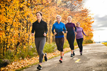Woman Group Out Running Together In An Autumn Park They Run A Race Or Train In A Healthy Outdoors Lifestyle Concept