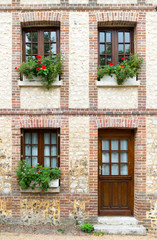 Sticker - typical Normandy architecture house front with stone and brick facade and colorful flowerpots