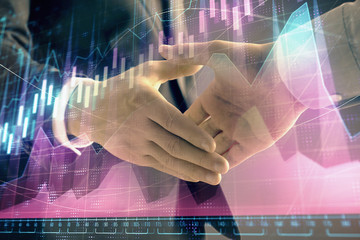 Multi exposure of forex graph on abstract background with two businessmen handshake. Concept of success on stock market