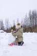© pictures_for_you - Happy child make a snowman in a snow-covered field in the countryside.