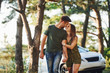 © standret - Having a walk. Car behind. Beautiful young couple have a good time in the forest at daytime