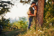 © standret - Leaning on the tree. Beautiful young couple have a good time in the forest at daytime