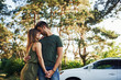 © standret - Standing near the white automobile. Beautiful young couple have a good time in the forest at daytime