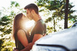 © standret - Front part of white car. Beautiful young couple have a good time in the forest at daytime