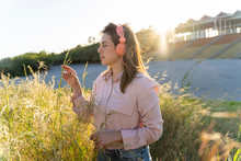 Young Woman Listening Music With Headphones Outdoors