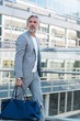 © Daniel Ingold/Westend61 - Fashionable mature, businessman with travelling bag on the go