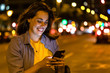© Josep M Rovirosa/Westend61 - Young woman using smartphone in the city at night