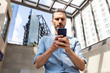 © WILLIAM PERUGINI/Westend61 - Serious businessman looking at the smartphone in the city, Berlin, Germany