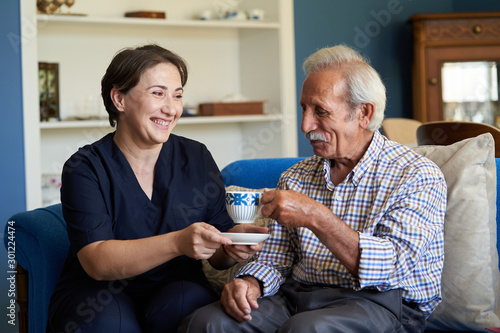 Fotomural Professional helpful caregiver and a senior man during home visit