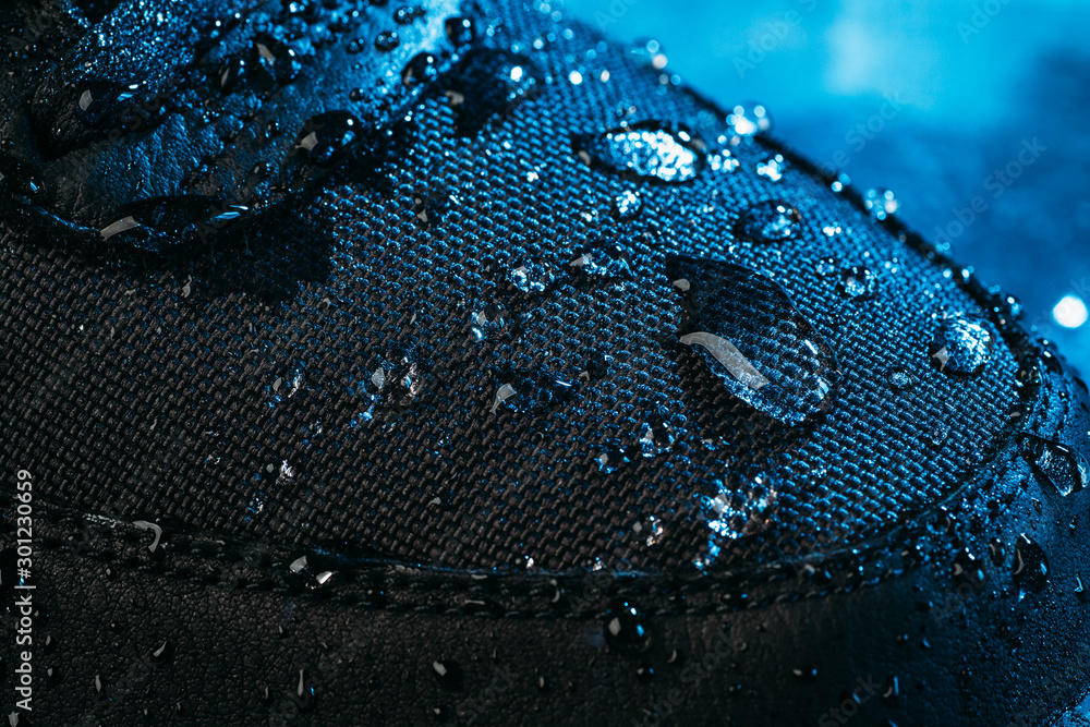 Water drops on waterproof membrane fabric of shoes surface, macro shot. New waterproofing technology for wear and footwear for active lifestyle. - obrazy, fototapety, plakaty 