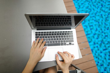 Wall Mural - view from above woman fingers pressing keyboard on laptop sunny