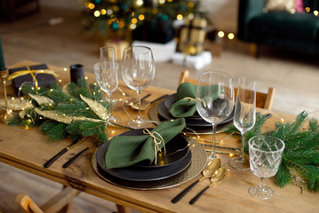 Table served for Christmas dinner in living room, close-up view, table setting, Christmas decoration.