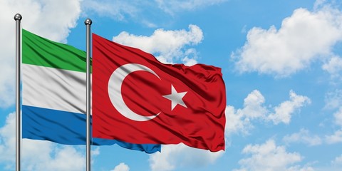 Sierra Leone and Turkey flag waving in the wind against white cloudy blue sky together. Diplomacy concept, international relations.