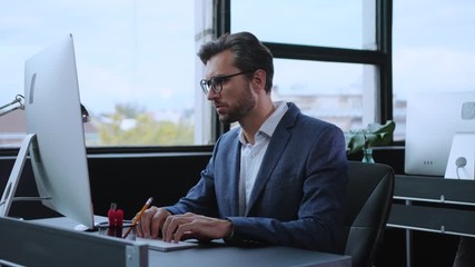 caucasian office executive working on modern computer desktop in the company. surprised frustrated y