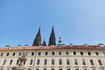 View from below on two Gothic towers and a building in Prague, Czech Republic.