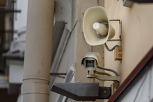 Cctv And Loudspeaker. Outdoor Surveillance And Tracking Security Camera With A Megaphone On The Wall Of Building.