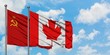 Soviet Union and Canada flag waving in the wind against white cloudy blue sky together. Diplomacy concept, international relations.