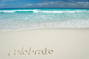 Wall Mural - celebrate message handwritten on a deserted tropical beach with blue waves crashing above smooth san