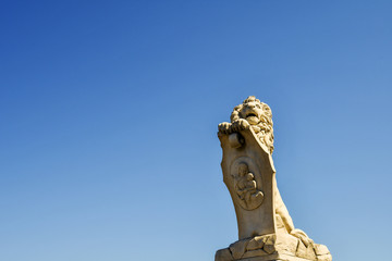 Sticker - Close-up of a marble statue of a lion holding a sign depicting Saint Mary with Baby Jesus, placed on one side of Solferino Bridge in Pisa, Tuscany, Italy