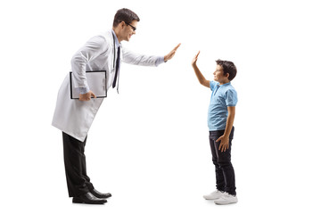 Wall Mural - Male doctor giving a high-five to a little boy