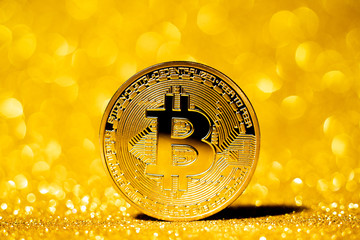 Bitcoin virtual cryptocurrency on gold glitter background