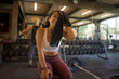 © TheVisualsYouNeed - natural fitness club lifestyle portrait of young happy and attractive Asian woman training at gym bench wiping the sweat with towel smiling cheerful and positive