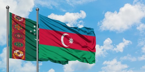 Turkmenistan and Azerbaijan flag waving in the wind against white cloudy blue sky together. Diplomacy concept, international relations.