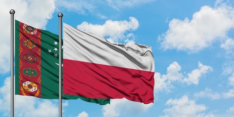 Turkmenistan and Poland flag waving in the wind against white cloudy blue sky together. Diplomacy concept, international relations.