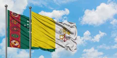 Turkmenistan and Vatican City flag waving in the wind against white cloudy blue sky together. Diplomacy concept, international relations.