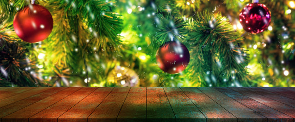 top wood desk with christmas tree and red ball hanging blur background,wooden table